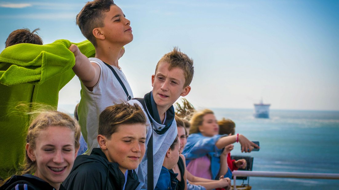 Молодые люди на палубе корабля наслаждаются видом.