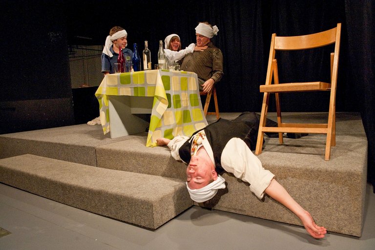 Театрализованная сцена, в которой пьяный лежит на земле.
