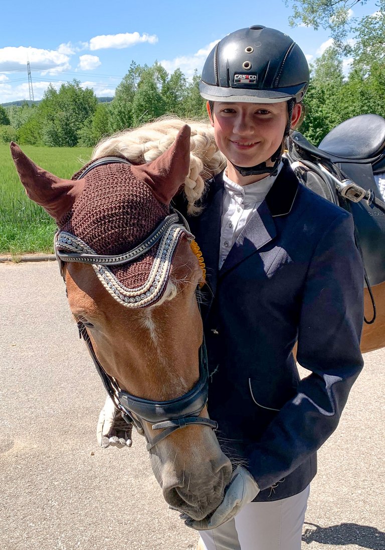 Выпускница средней школы Антония фон дер Шуленбург в турнирной ситуации ведет лошадь 