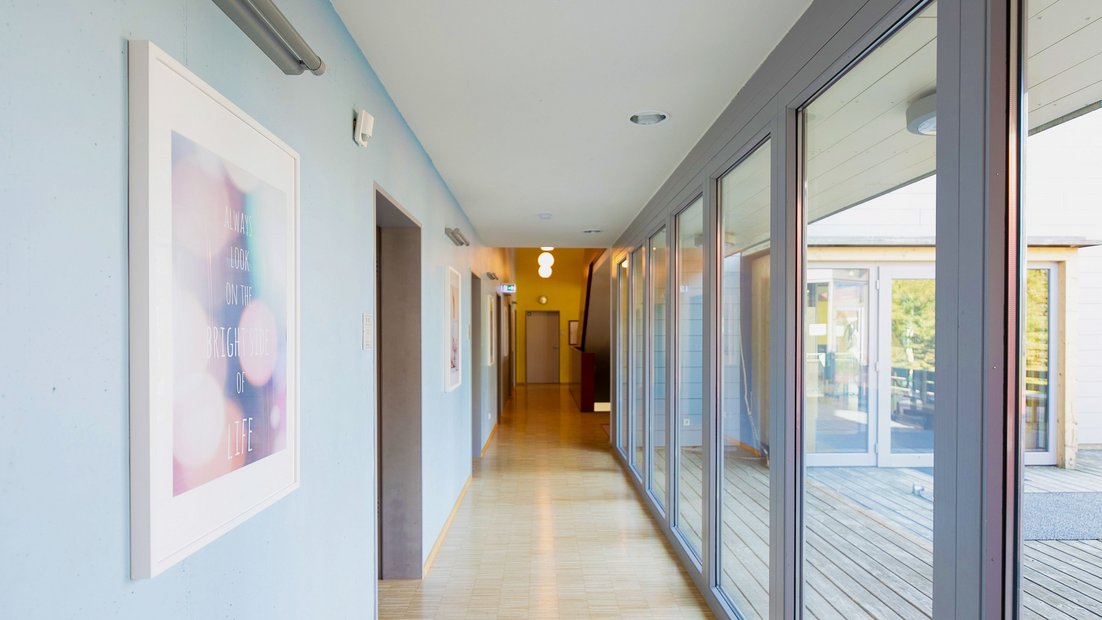 Вид на коридор Визенхауса с фотографиями слева и окном справа.