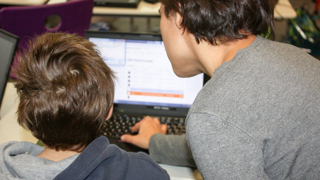Два студента ищут медиа на своем ноутбуке